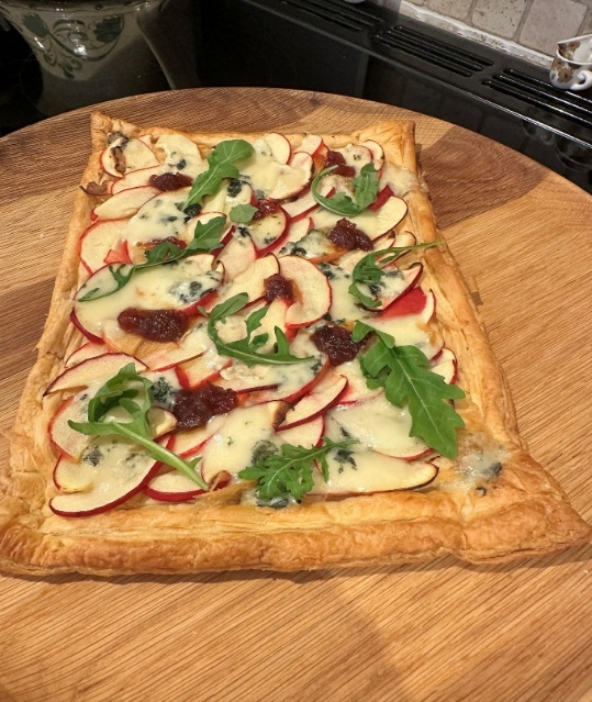 A square pizza with apples and cheese on a wooden surface AI-generated content may be incorrect.
